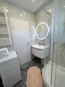 a bathroom with a shower and a sink and a tub at Villa Strma in Primošten