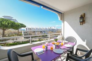 una mesa púrpura en un balcón con vistas en Studio Daisy / charmant / Terrasse / lumineux / plage à 5 min, en La Grande-Motte