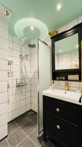 y baño con lavabo y ducha con espejo. en ApartmentInCopenhagen Apartment 1494, en Copenhague