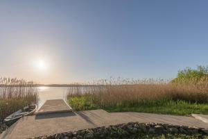 a dock on a lake with the sun in the sky at Haus am See in Torgelow am See