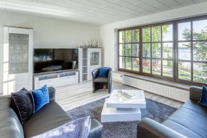 a living room with a couch and a tv at Haus am See in Torgelow am See