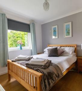una camera da letto con un grande letto e una finestra di Immaculate Gower Getaway with Pool & Facilities a Swansea