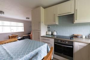 a small kitchen with a bed in a room at Immaculate Gower Getaway with Pool & Facilities in Swansea