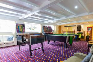 a living room with a pool table and ping pong ball at Immaculate Gower Getaway with Pool & Facilities in Swansea