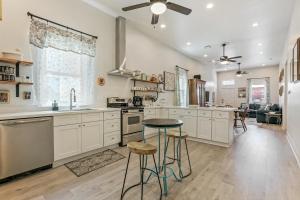 a kitchen with white cabinets and a table and stools at Renovated Historic 4BR House Near Magazine St & Uptown in New Orleans