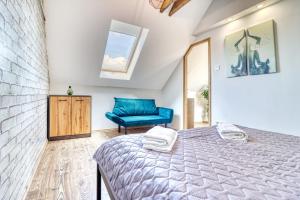 a bedroom with a bed and a blue chair at ZenLoft Apartman in Eger