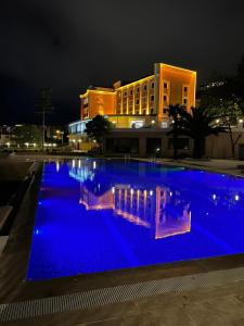 a large swimming pool with blue lighting in front of a building at THE SİGN DEGİRMEN OTEL in Istanbul