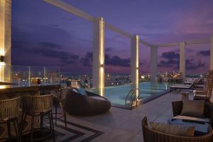 春武里的住宿－Hotel Nikko Amata City Chonburi，屋顶酒吧,晚上可欣赏到城市美景