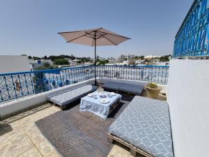a patio with a table and an umbrella on a balcony at Cosy 1bdr, with a terasse in heart of Sidibou in Sidi Bou Saïd