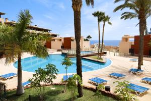 an image of a resort pool with palm trees and the ocean at Best duplex FREE WIFI in Playa Paraiso