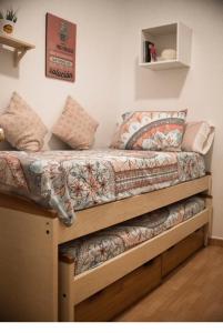 ein Bett mit einer Bettdecke und Kissen darauf in der Unterkunft NICE HOME city center in Melilla