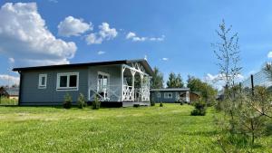 uma pequena casa com um alpendre num campo verde em Trzy Jeziora Okuninka em Okuninka