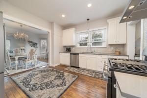 a kitchen with white cabinets and a dining room at Relax at this charming and cozy downtown retreat in Grand Junction