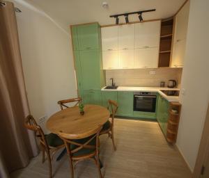 a kitchen with green cabinets and a wooden table and chairs at Luxury Mare apartment in Bar