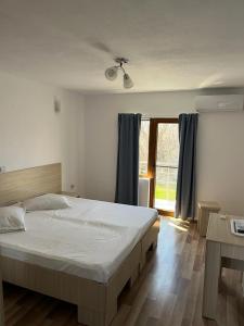 a bedroom with a large bed and a window at Vila Angi in Mangalia