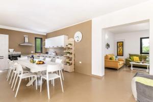 uma cozinha e sala de estar com uma mesa branca e cadeiras em Villa Trullo Lofino by Villa Plus em Carovigno