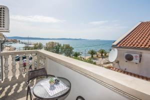 a balcony with a table and a view of the ocean at Apartment Velika obala 2 in Bibinje
