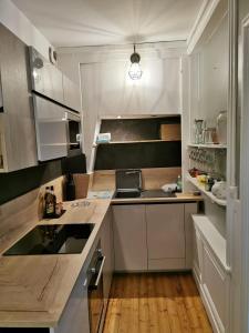 een keuken met witte kasten en een aanrecht bij Appartement de charme in Honfleur