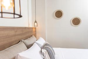 a bedroom with a bed with a wooden headboard at Noemie Premium Holiday Apartments in Pefkohori