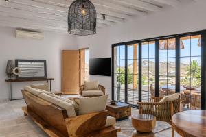 a living room with a couch and chairs and a table at ELEMENTS Mykonos Villa in Mikonos