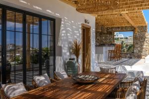a patio with a wooden table and chairs at ELEMENTS Mykonos Villa in Mýkonos City