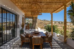 einen Essbereich im Freien mit einem Tisch und Stühlen auf einer Terrasse in der Unterkunft ELEMENTS Mykonos Villa in Mykonos Stadt