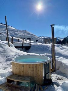 ザンクト・アンテーニーンにあるBerglodge Ascharinaのスキー場の雪中のホットタブ