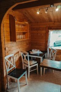 a room with a table and chairs in a cabin at Holzhaus direkt am See in Priepert