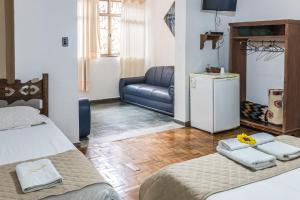 ein Wohnzimmer mit 2 Betten und einem Sofa in der Unterkunft Pousada dos Sinos in São João del Rei