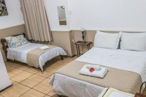 a hotel room with two beds and a mirror at Pousada dos Sinos in São João del Rei