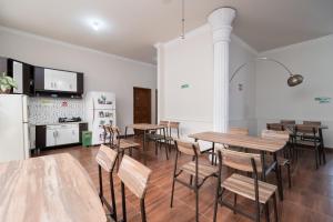 a room with tables and chairs and a kitchen at KoolKost Syariah @ Cempaka Putih (Minimum Stay 6 Nights) in Jakarta