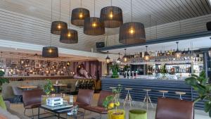 a restaurant with a bar with tables and chairs at EuroParcs Marina Strandbad in Olburgen +41 photos