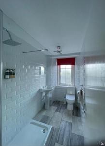 a white bathroom with a toilet and a sink at Portsonachan Hotel & Lodges in Dalmally
