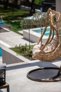 a wicker chair sitting on a patio next to a pool at Delight Luxury Villa - Contemporary Elegance & Tranquility, by ZanteWize in Zakynthos Town +67 photos