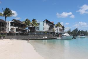a house on the beach with a boat in the water at Auberge Miko in Grand Baie