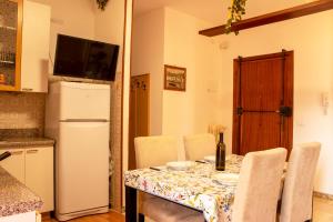 kuchnia ze stołem z krzesłami i lodówką w obiekcie [POSTO AUTO GRATUITO] Relax a 30 metri dal mare w mieście Riva Ligure