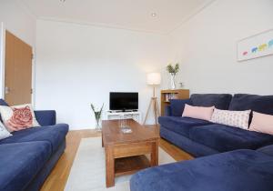 a living room with blue couches and a coffee table at Law View in North Berwick