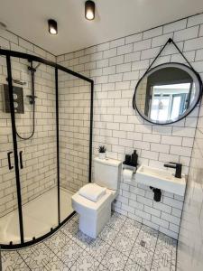 W łazience znajduje się toaleta, umywalka i lustro. w obiekcie One of a Kind Luxury Studio Stay in Penzance w mieście Penzance
