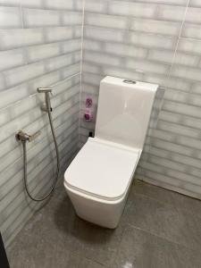 a white toilet in a bathroom with a shower at Teratak Sekayu ( Room Stay ) in Kuala Kerau
