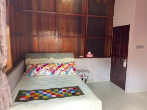 1 dormitorio con 1 cama con pared de madera en Teratak Sekayu ( Room Stay ) en Kuala Kerau