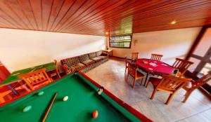 a room with a pool table and a dining room at Pousada Albuquerque in Teresópolis
