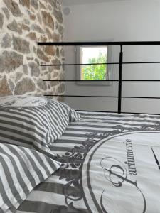 - une chambre avec un lit et un mur en pierre dans l'établissement Sainte Victoire le Cabanon, à Puyloubier