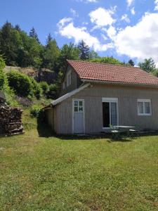 mały domek na podwórku z trawnikiem w obiekcie Au garni w mieście Thiéfosse