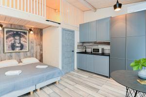 a bedroom with a bed and a table and a kitchen at Bastiono apartamentai in Klaipėda