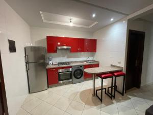 馬提的住宿－Samo appart，厨房配有红色橱柜和红色凳子的桌子