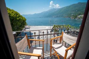 uma varanda com cadeiras e vista para um corpo de água em Hotel la Meridiana, Lake & SPA em Ascona