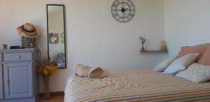 ein Schlafzimmer mit einem Bett mit einer Uhr an der Wand in der Unterkunft Boulouris Panorama Vue mer in Saint-Raphaël