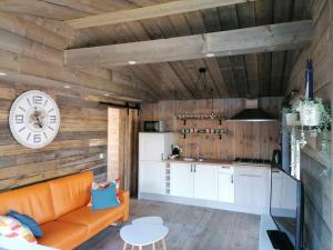 a living room with a couch and a kitchen at Le canard: rustig genieten aan het water in Geel