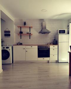 - une cuisine avec des appareils électroménagers blancs et un mur en briques blanches dans l'établissement Laurel No5, à Logroño