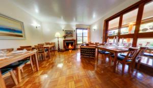 a dining room with tables and chairs and a fireplace at Pousada Albuquerque in Teresópolis
